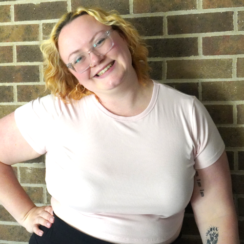 Megan smiles at the camera tilting her head to one side. She's got pizazz!